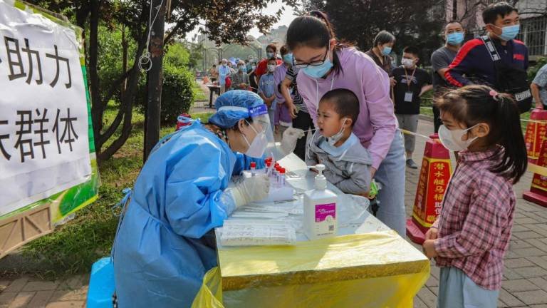 Médicos toman test de Covid-19 a niños en China. FOTO:AFP